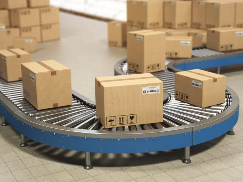 Cardboard boxes on conveyor roller in distribution warehouse.