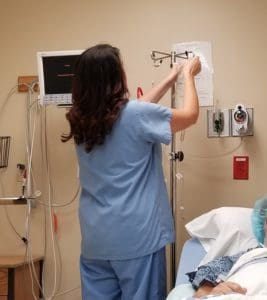 Nurse Hanging a Bag on an IV Pole