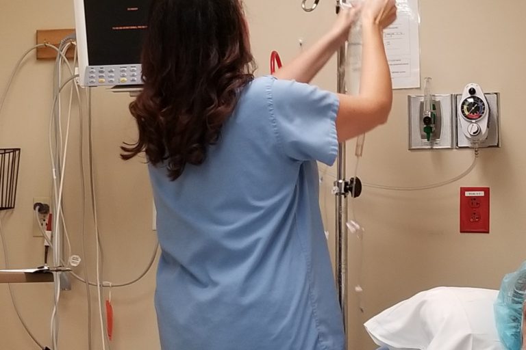 Nurse Hanging a Bag on an IV Pole
